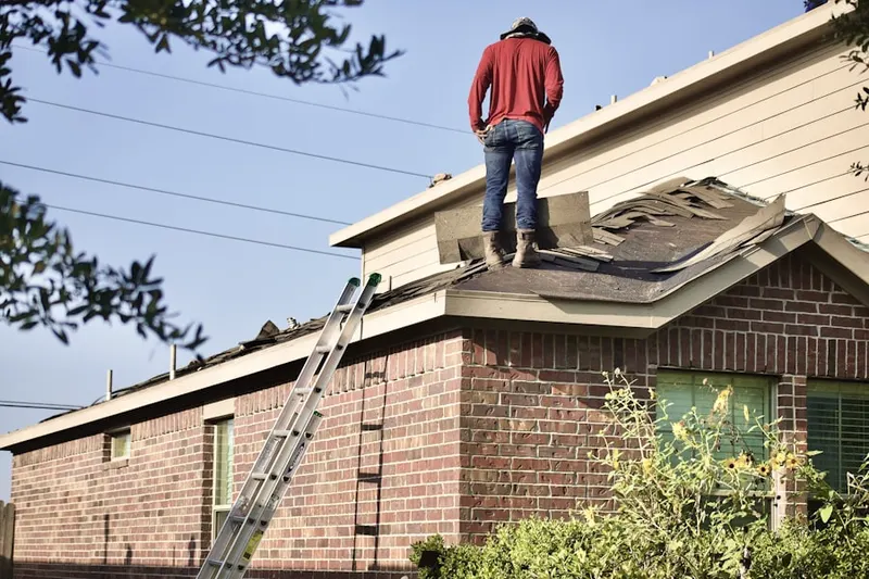 Professional roofer working on a residential roof in Sams Creek